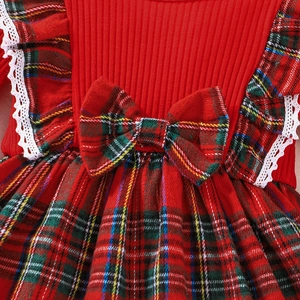 Detail of girls' Christmas dress showing red ribbed bodice, plaid bow, and lace trim