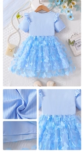 Detail of light blue girls dress featuring 3D butterfly appliqués and ruffled mesh layers