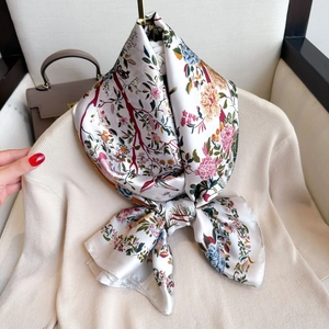 Floral satin silk scarf with colorful botanical print worn on beige knitwear