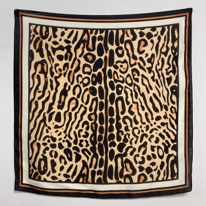 Detail of square silk scarf showing classic leopard print pattern and black border