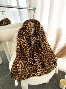 Close-up of leopard print scarf fabric showing the detailed brown and black animal texture