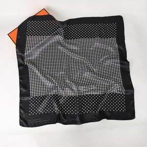 Detail of satin square scarf with houndstooth pattern and dots on a smooth silk texture
