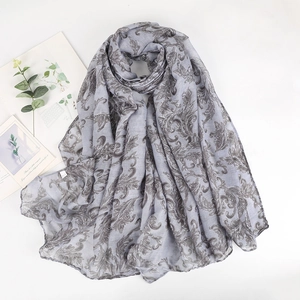 Detailed view of grey paisley cotton scarf with elegant baroque leaf print on white surface