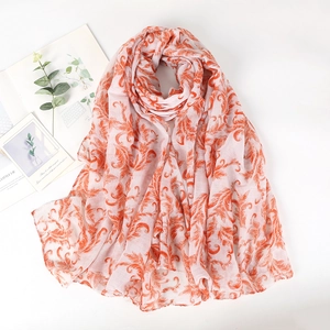 Detail of lightweight white scarf with orange baroque leaf pattern on cotton linen fabric