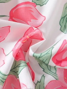 Gros plan d'une robe fleurie pour filles avec imprimés tulipes roses et tissu blanc