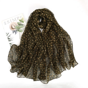 Detailed close-up of dark olive green voile scarf with heart prints on white background