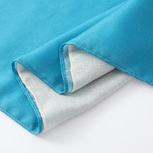 Détail de l'écharpe en coton et lin dégradé bleu montrant la qualité de la finition