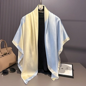 Blue and yellow block-colored satin silk scarf draped elegantly over a black shirt