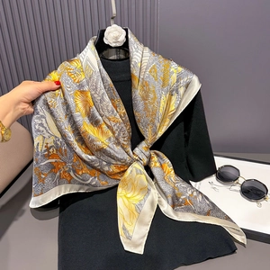 Floral satin square scarf in yellow and grey draped on a stylish black blouse