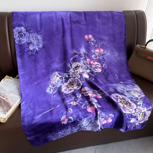 Elegant purple silk scarf with peony floral print displayed on a leather sofa