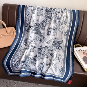 Seidenschal mit blau-weißem Toile-de-Jouy-Muster und Tiermotiven auf Ledersofa drapiert