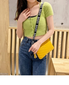 Détail du sac bandoulière jaune surpiqué en V avec bandoulière imprimée LOVE