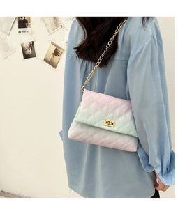 Model wearing gradient quilted shoulder bag with golden chain and metallic turn-lock
