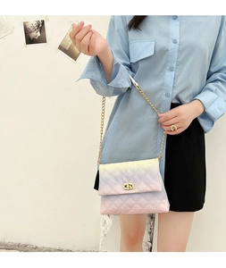 Model wearing a gradient quilted crossbody bag with a gold chain strap and metal turn lock
