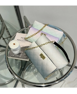 Detail of gradient quilted crossbody bags with gold turn-lock and chain strap