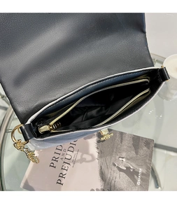 Detail view of rhombic pattern leather shoulder bag with gold chain and interior zip pocket