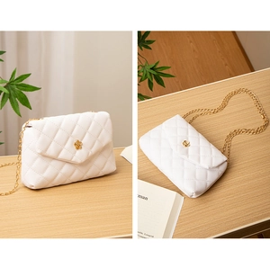 Détail du sac bandoulière blanc matelassé avec boucle fleur dorée et bandoulière chaîne