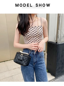 Mannequin portant un sac seau noir matelassé avec poignée perle et bandoulière en chaîne