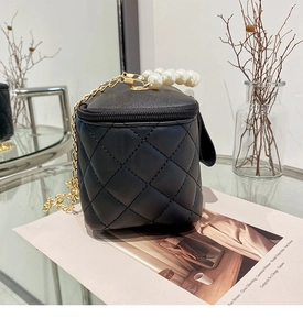 Détail du mini sac boîte matelassé noir avec poignée en perles et chaîne dorée