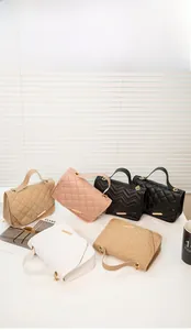 Close-up of quilted chain bags in beige pink black and white showing stitch textures