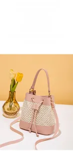 Detail of pink leather woven bucket bag with drawstring closure and gold hardware