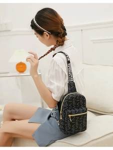 Close-up of black crossbody bag with white VIFN logo print and golden metal zippers