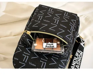Macro detail of the front pocket on a black pebble leather chest bag with gold zipper