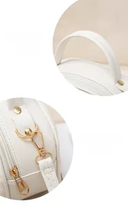 Detail of white PU leather bag with heart-shaped zipper pull and pale gold hardware