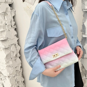 Pink and white gradient quilted crossbody bag with gold chain strap on model