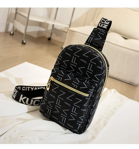 Close-up of black crossbody bag with logo print pattern and wide jacquard shoulder strap