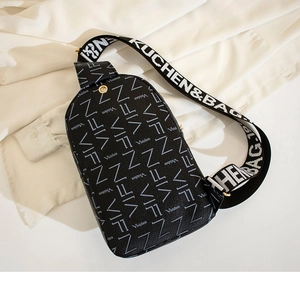 Detail of black crossbody bag featuring white alphabet prints and a wide textile strap
