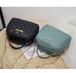 Close-up of quilted crossbody bags in black and green with golden chain straps
