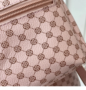 Close-up of light pink lychee leather with floral print and premium metal zipper