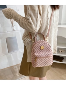 Detail of pink mini backpack with geometric polka dot pattern and gold metal hardware