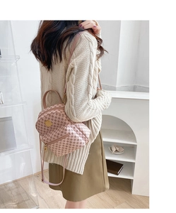 Detail view of mini pink monogram backpack worn by a model in a modern interior