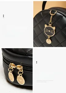 Detail of quilted leather mini round bag with cat-shaped gold charm and double zipper
