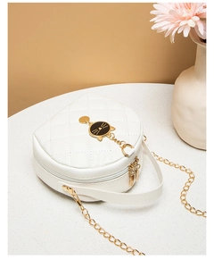 Detail of white quilted mini bag featuring cat-shaped metal clasp and gold chain strap