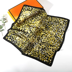 Macro detail of leopard print silk scarf texture and elegant satin glossy finish