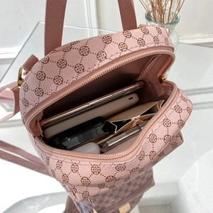Pink monogram mini backpack with golden zippers showing interior storage for daily essentials