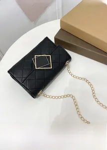 Detail der klassischen schwarzen Stepptasche mit goldener Schnalle und Kettenriemen