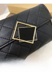 Detail der klassischen schwarzen gesteppten Lederstruktur und goldenem Taschenschloss