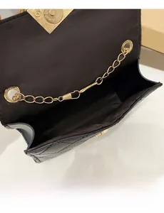 Detailansicht der schwarzen Stepptasche mit braunem Innenfutter und herzförmigem Schloss
