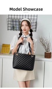 Close-up of black quilted tote bag with gold hardware and classic diamond pattern