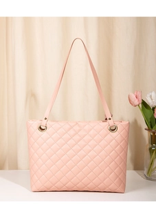 Detail of pink quilted tote bag showing fine diamond stitching and golden hardware