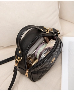 Detail view of black quilted mini bag showing interior capacity and lavender lining