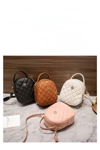 Sacs bandoulière ronds matelassés en noir, marron, blanc et rose avec boucle trèfle