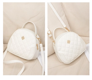 Close-up of quilted cream mini bag with golden clover logo and detachable strap details