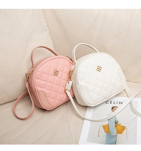 Detailed view of quilted faux leather handbags with gold flower hardware in pink and white