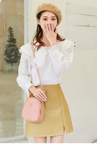 Sac bandoulière matelassé rose avec emblème de trèfle doré porté par un mannequin