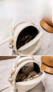 Détail du sac à bandoulière rond matelassé blanc montrant le rangement interne pour cosmétiques
